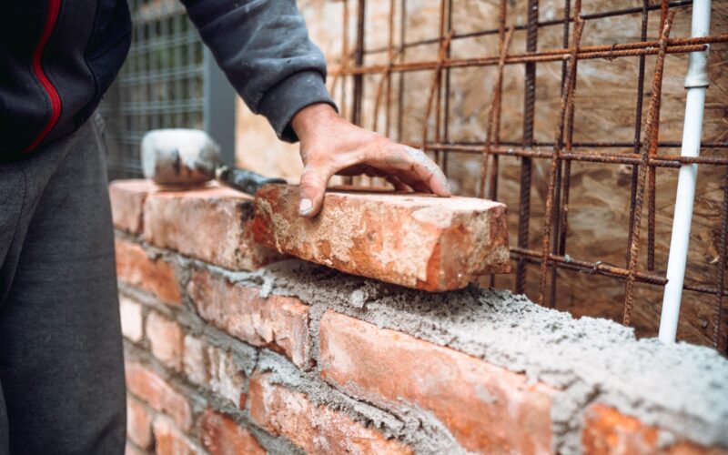 Murlegger | Flislegging | Ålgård mur og flis Close up of industrial bricklayer installing bricks on construction site. Construction works